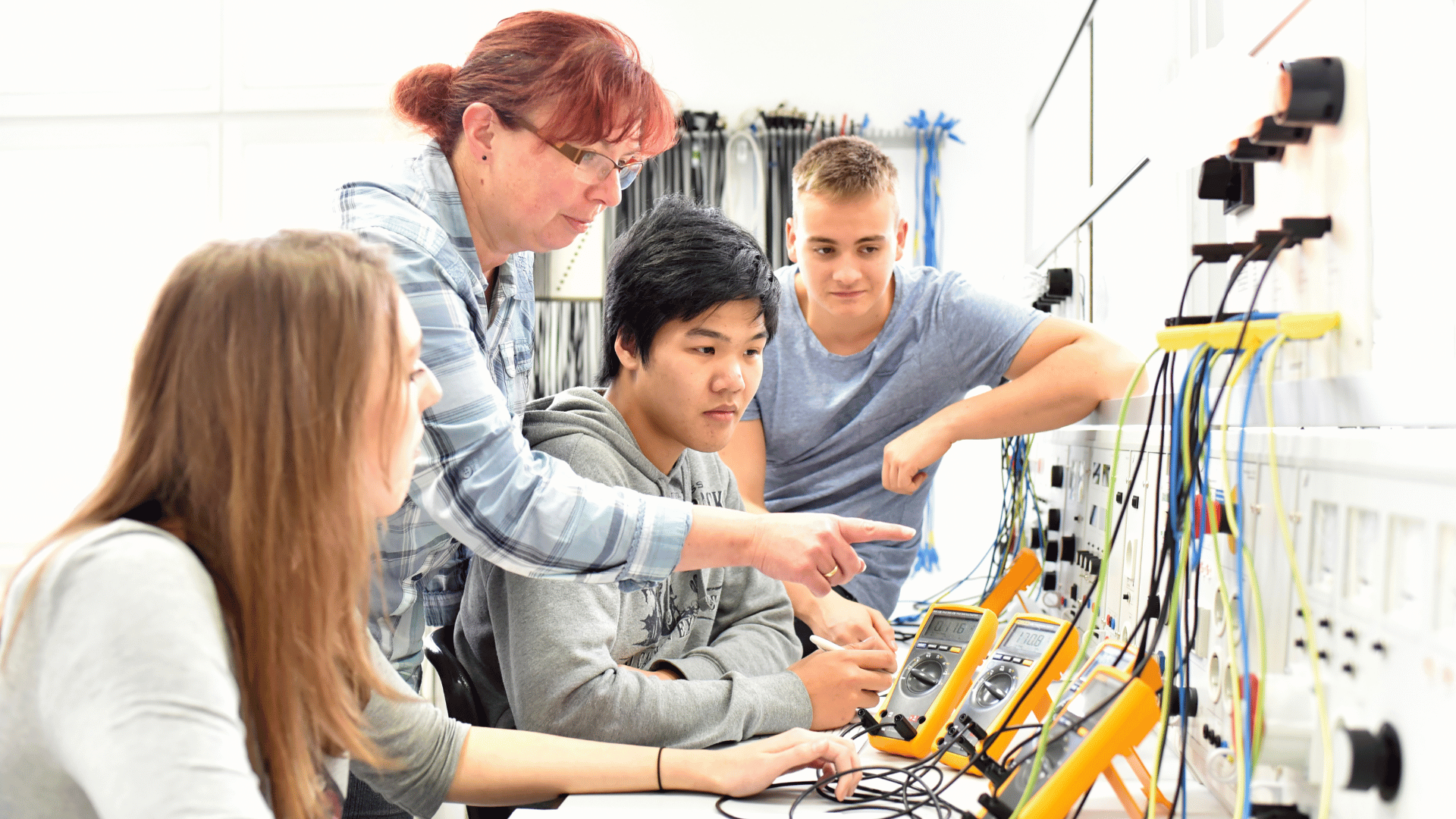 students and teachers studying a monitor