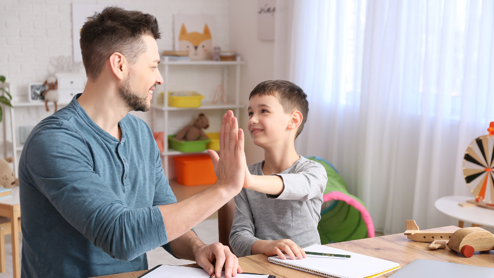 a young kid high-fiving an older adult