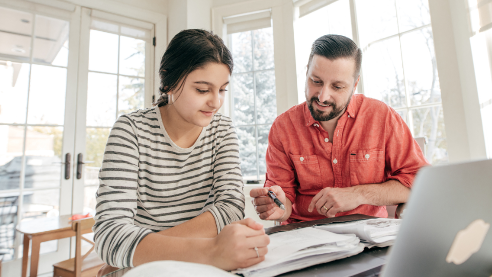 a parent and teenager working on homework together