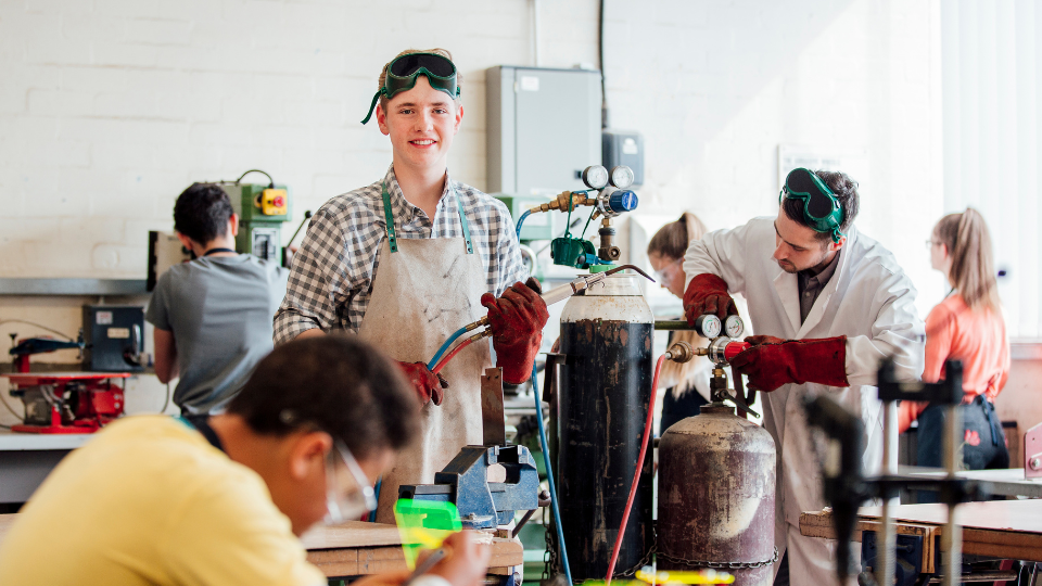 students smiling in a welding class