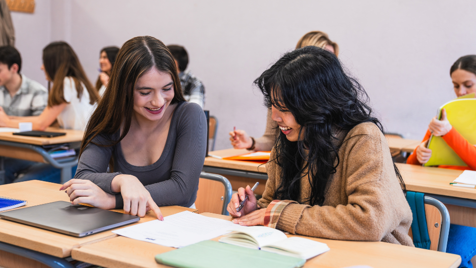 two students chatting inside a classroom