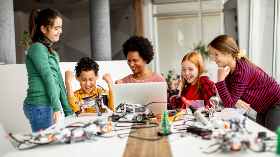 four middle school students engaged in career exploration with an adult