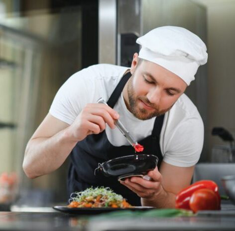 young male chef examining a dish